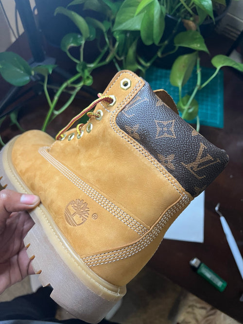 LV Timberland boot held in the workshop, plant in background